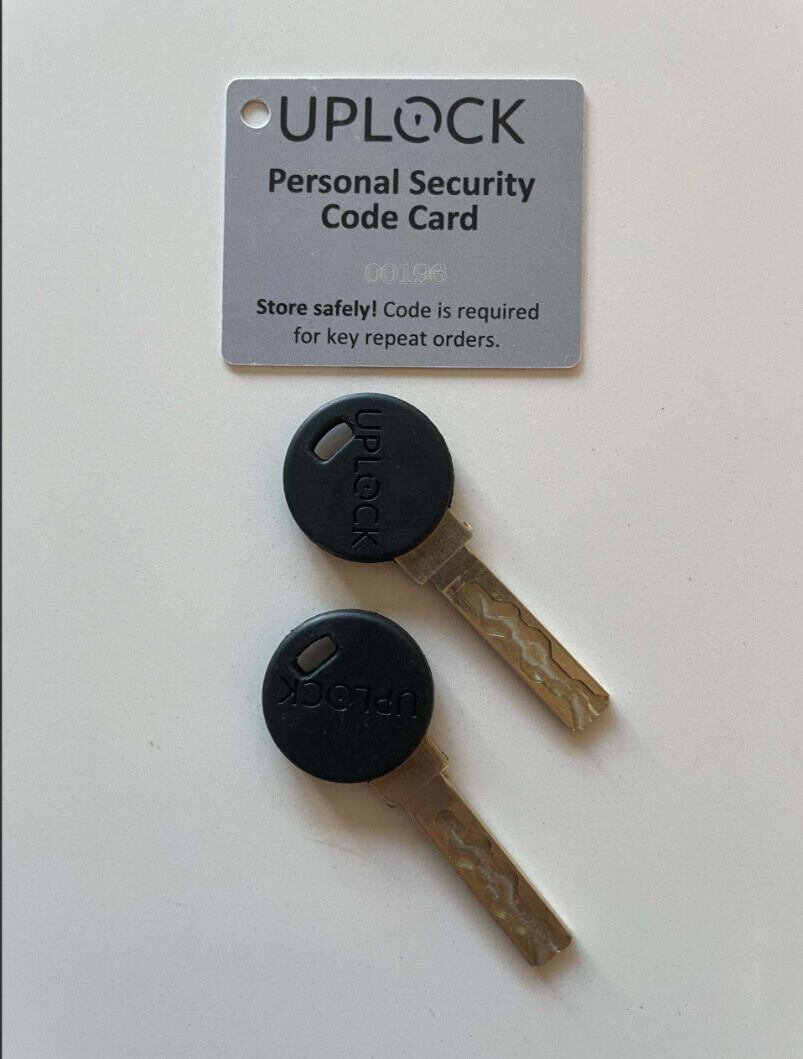 Zwei UPLOCK-Schlüssel und eine persönliche Sicherheitscodekarte zur sicheren Bestellung von Ersatzschlüsseln.