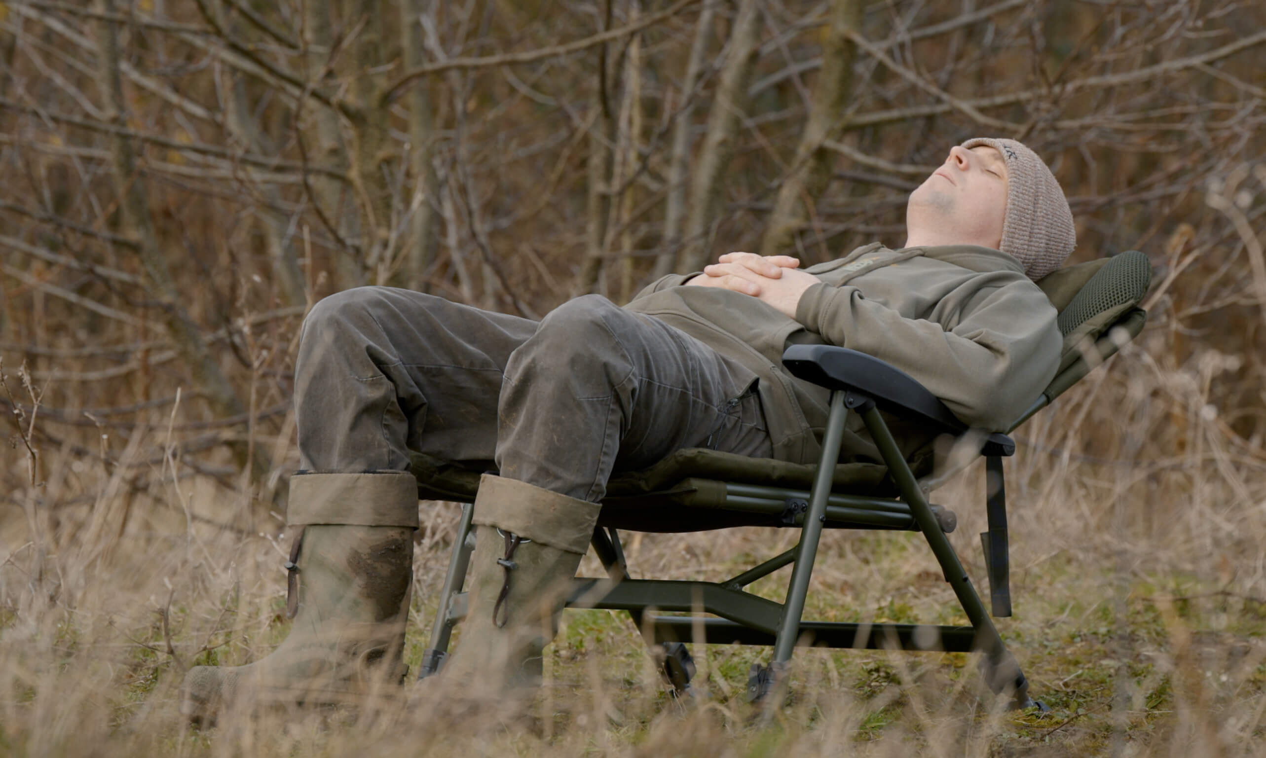 Ein entspannter Angler, der beim Angeln einen ruhigen Moment in der Natur genießt.