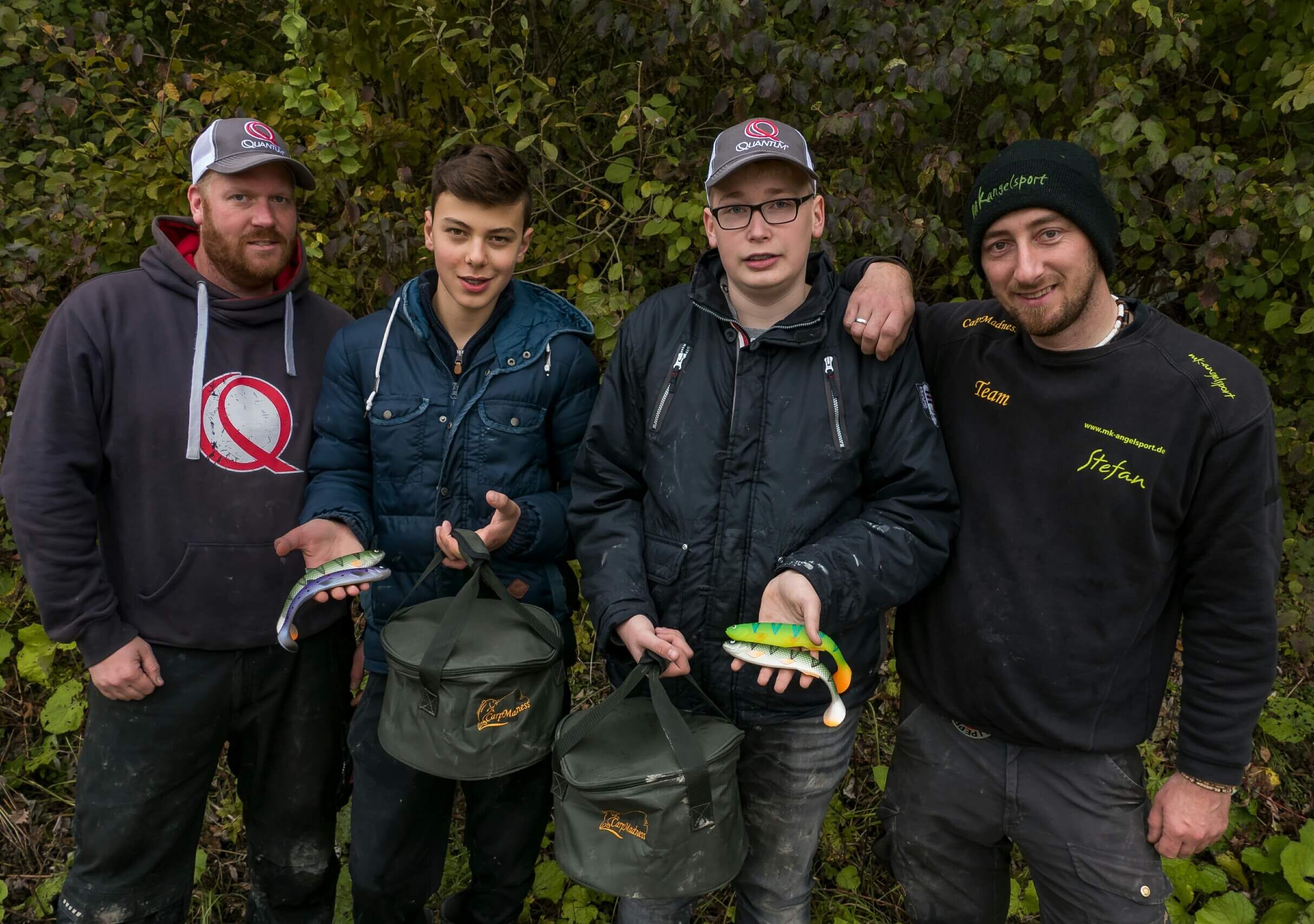 jugendangeln-angelsport Vier Angler präsentieren ihre Ausrüstung und Köder für erfolgreiches Karpfenangeln.