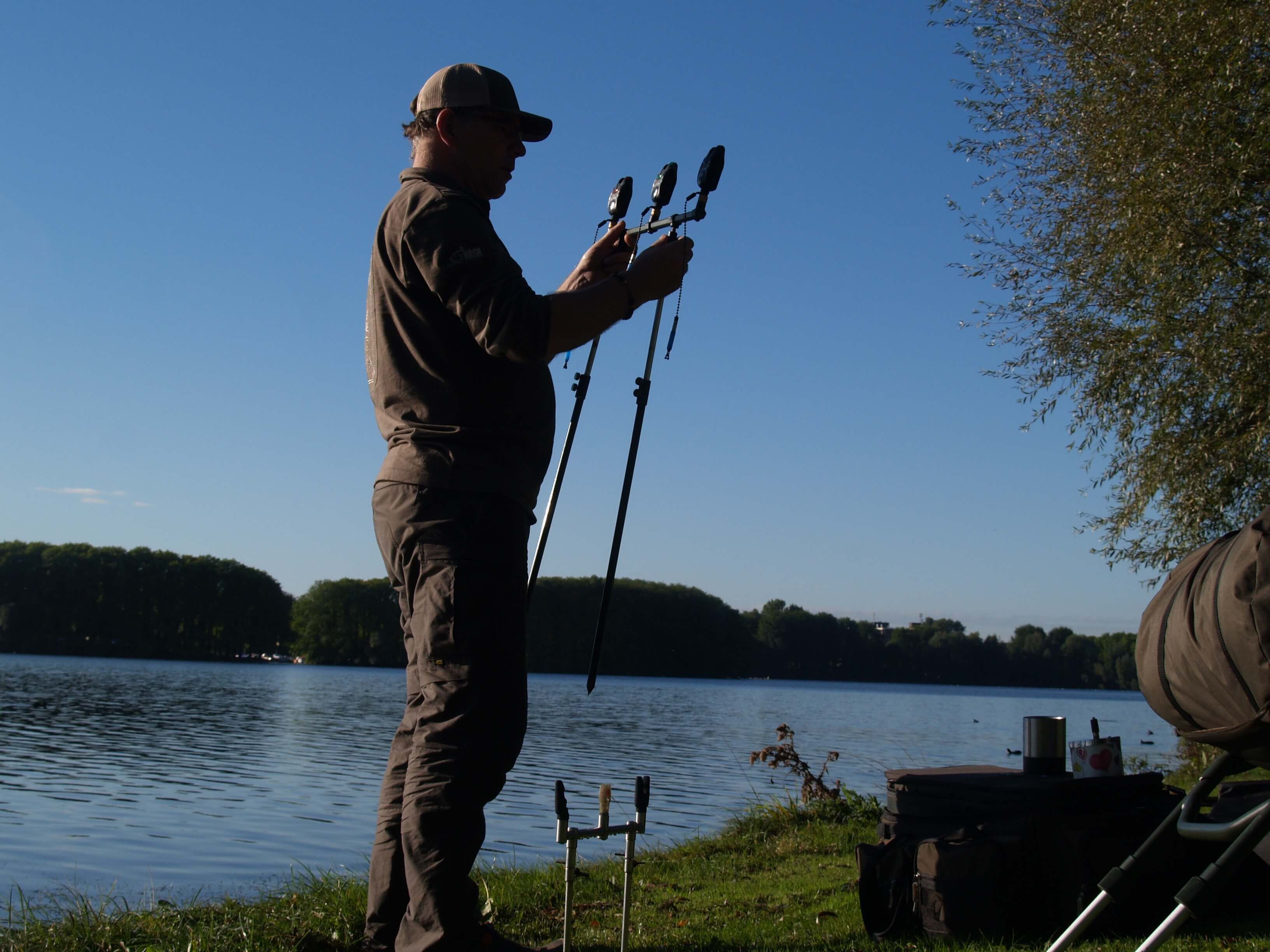 karpfenanglerqhDIfTRTeQRHI Angler installiert elektronische Bissanzeiger am See zum Karpfenangeln.