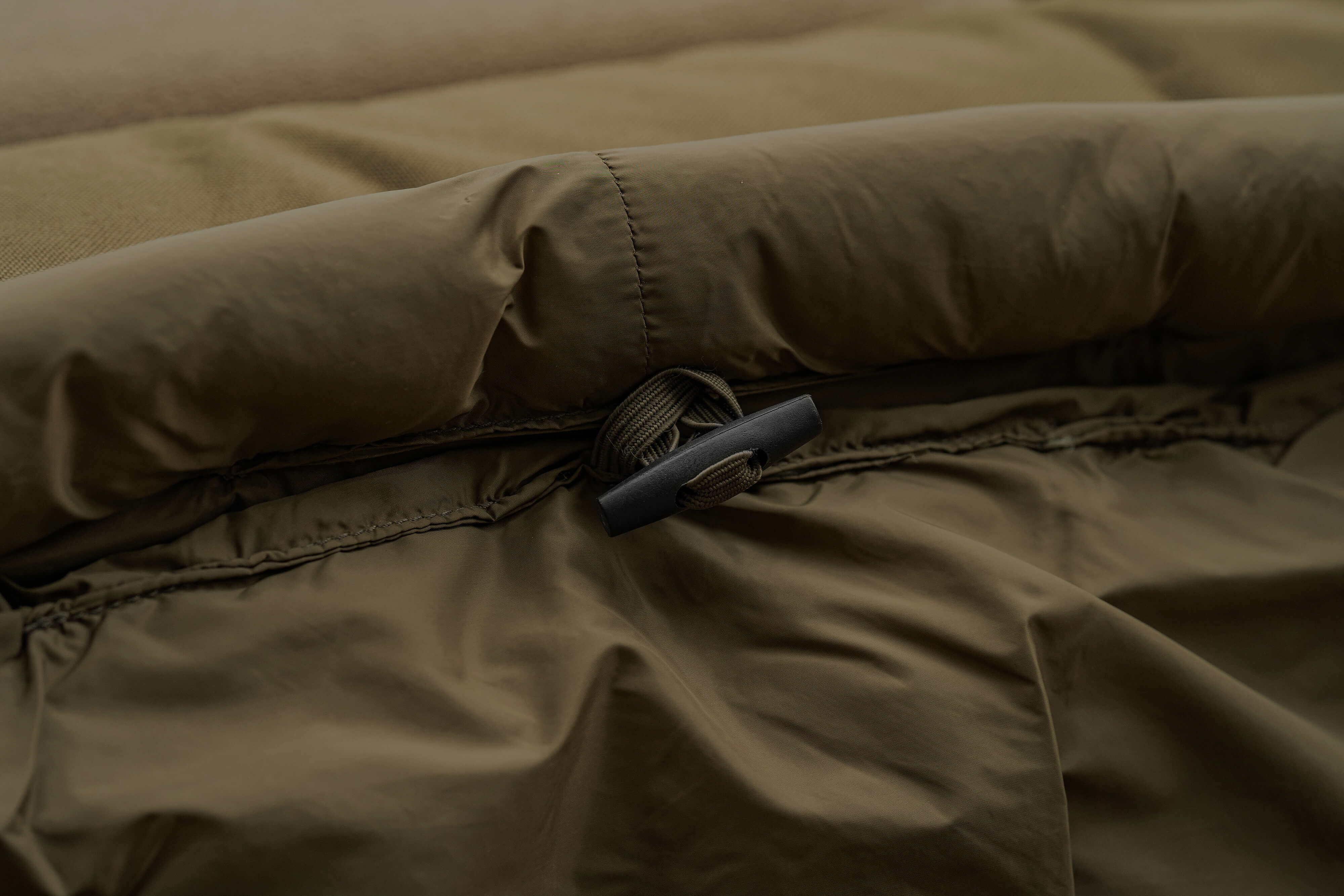 Primer plano de una cómoda silla tipo cama de pesca, perfecta para largas noches junto al agua mientras se pescan carpas.