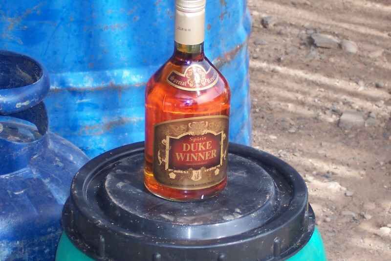Wiskey Eine Flasche Duke Winner Spirituose auf einem Fass, perfekt zum Entspannen nach dem Angeln.