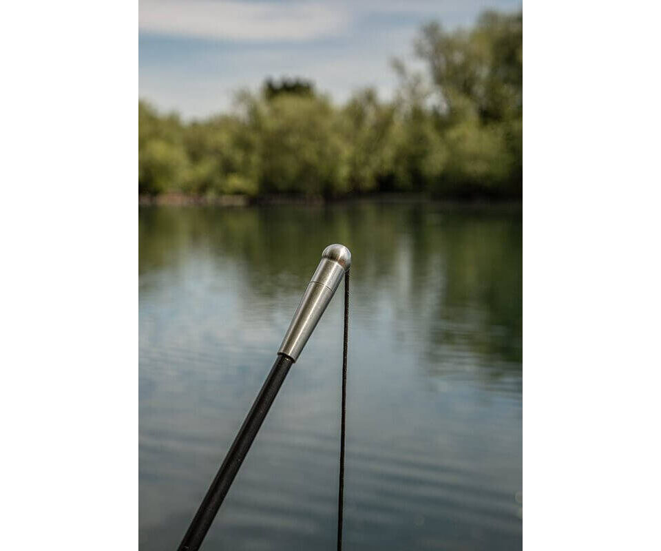 solar-tackle-P1BL42X-bow-loc-upgraded-4 Close-up van de punt van een hengel boven kalm water, perfect voor liefhebbers van karpervissen.