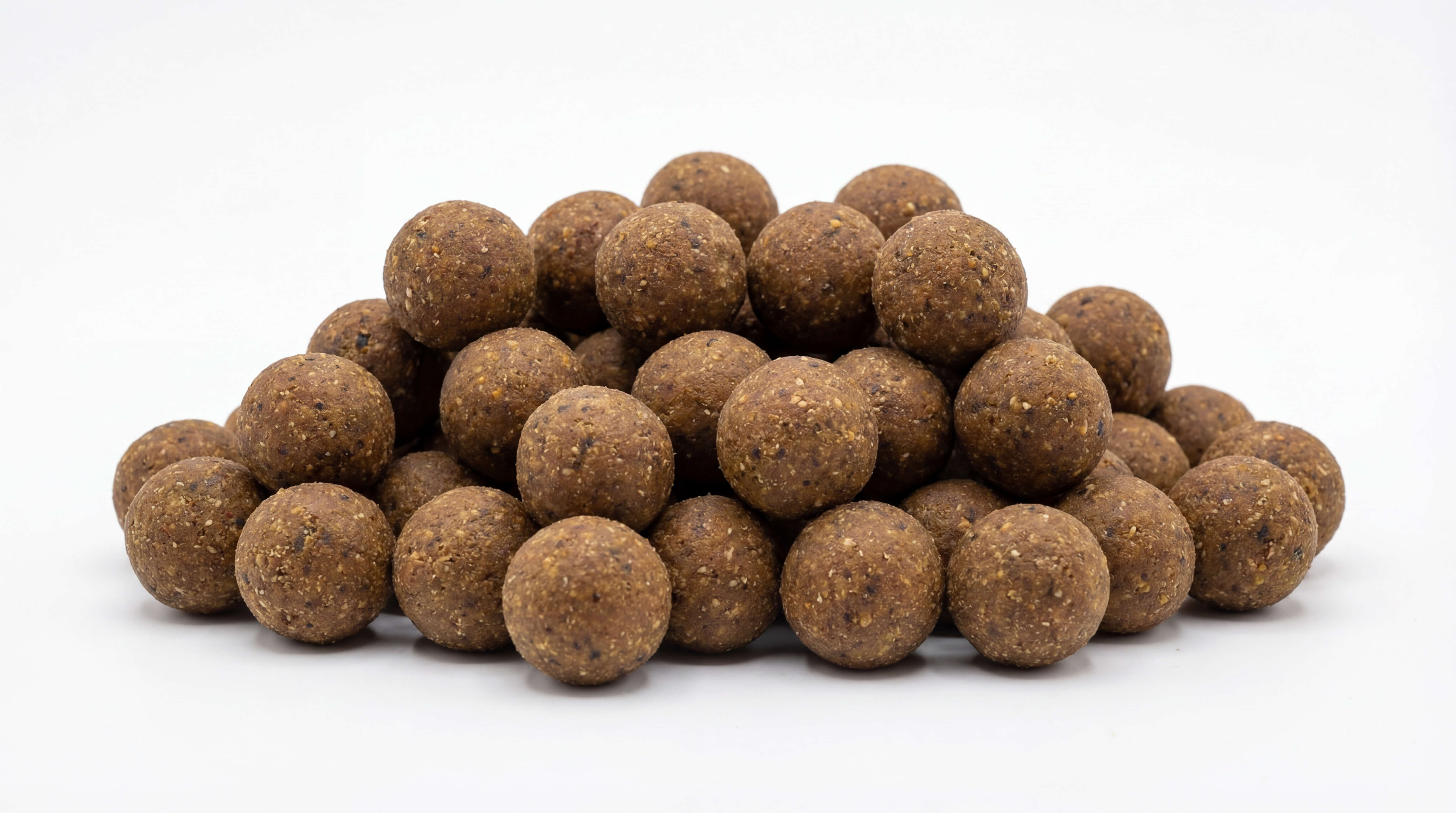 Un montón de bolas de cebo de pesca redondas y marrones elaboradas con ingredientes naturales, ideales para atraer peces.