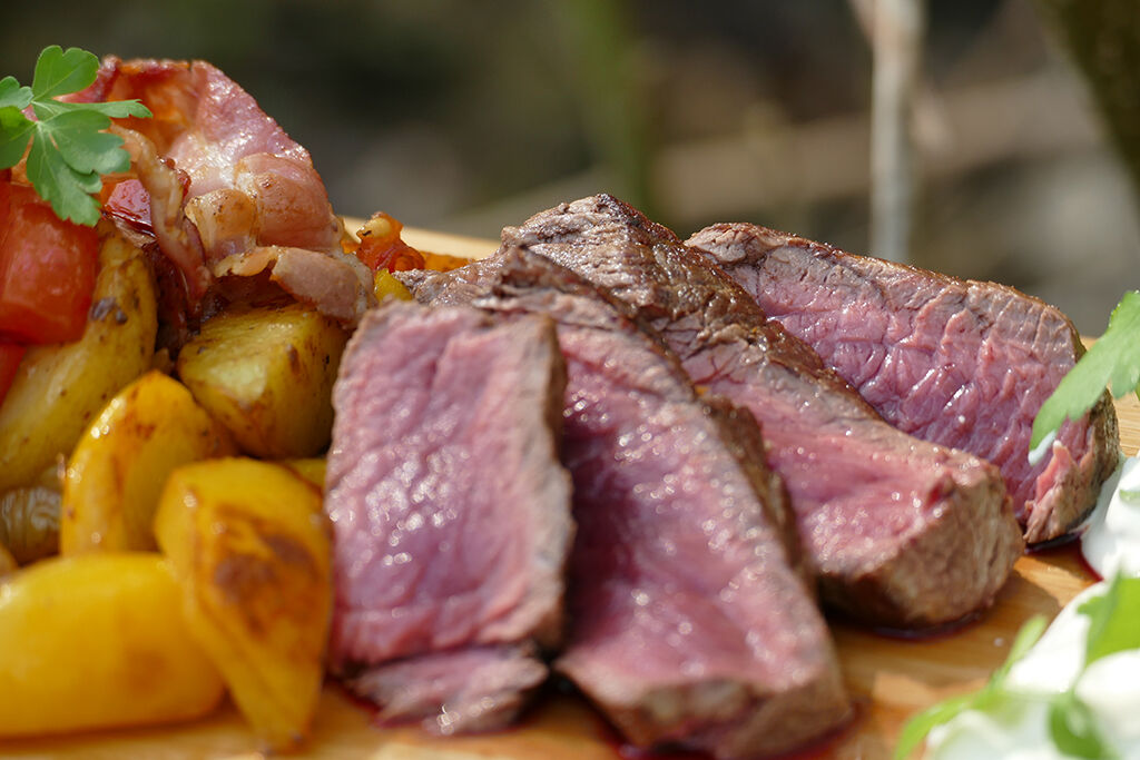 roastbeef-beim-angeln Köstliches gegrilltes Steak serviert mit knusprigen Kartoffeln und frischem Gemüse für Angler.