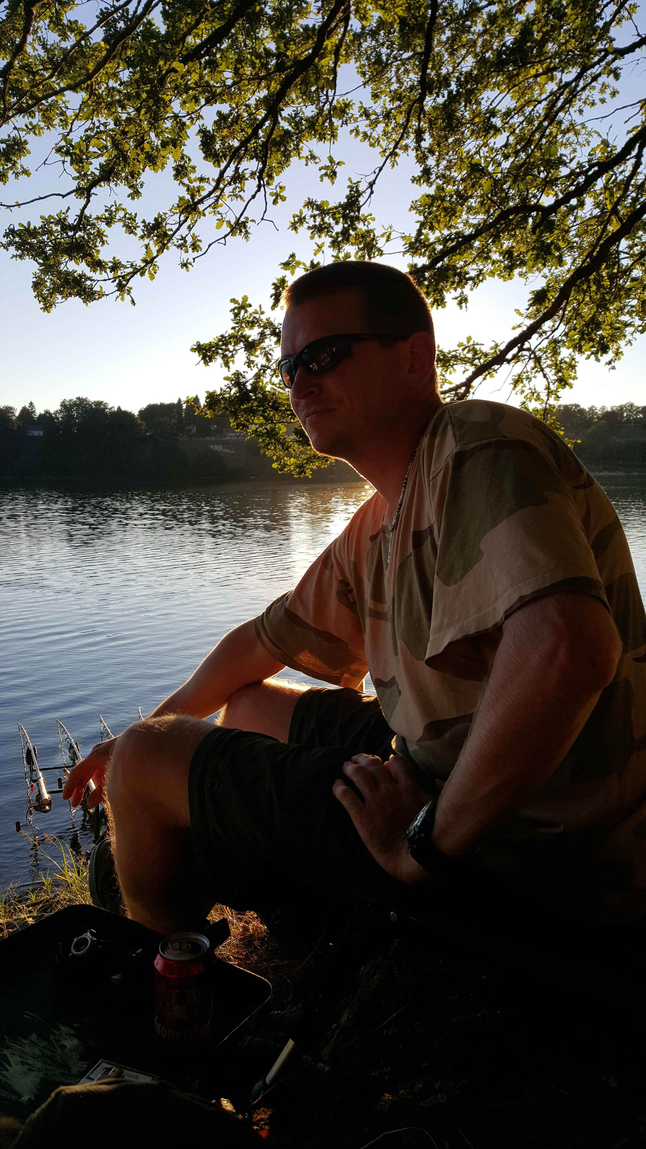 031b man, camouflage shirt, sunglasses, sitting by water, outdoor leisure