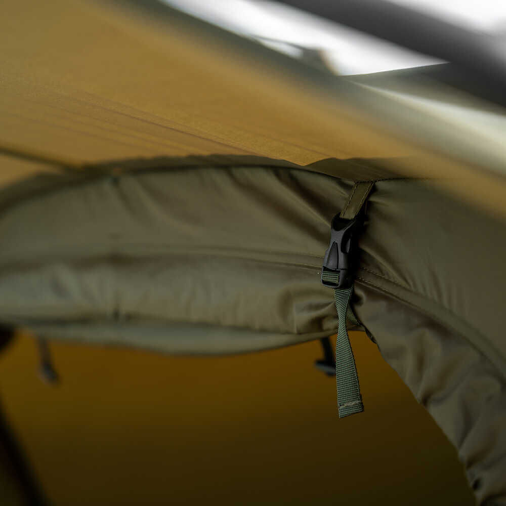 Primer plano de la sujeción segura de una tienda de pesca, perfecta para la comodidad de los pescadores de carpas.