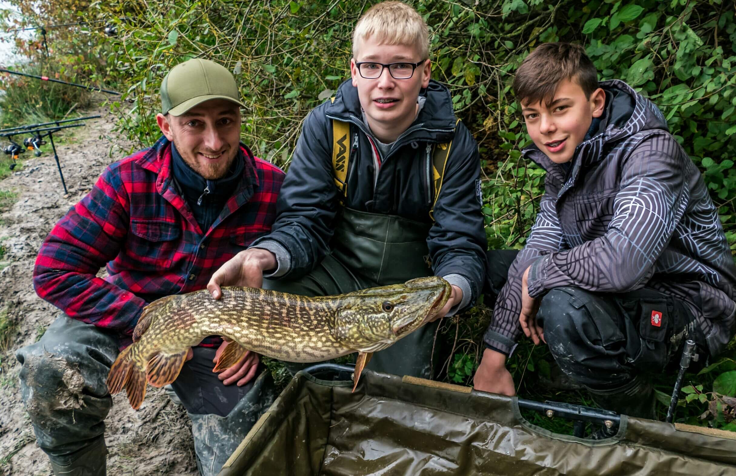 Die Jugend räumt ab – 24 Stunden auf Hecht und Karpfen Drei Angler zeigen stolz einen großen Hecht, der während eines Angelausflugs gefangen wurde.