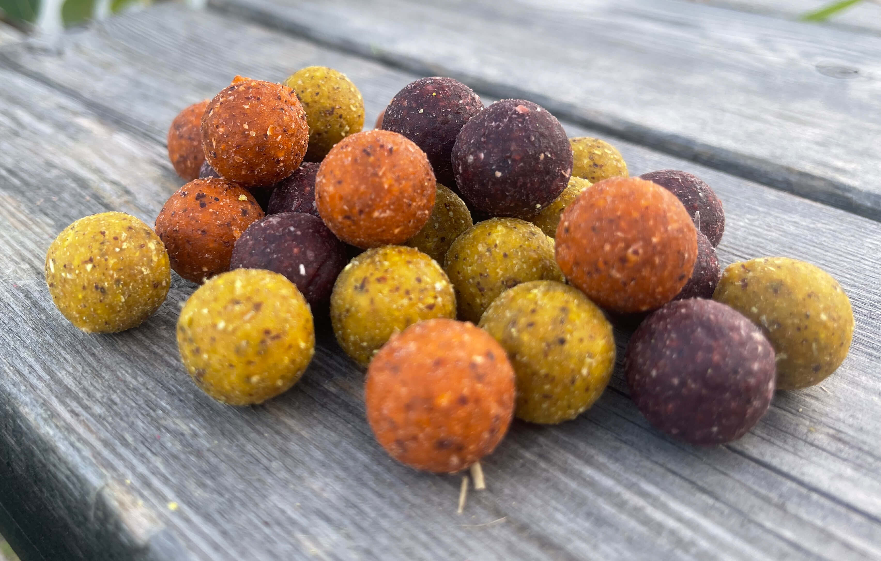 Un colorido surtido de Boilies de pesca de carpas ideales para atraer carpas durante las salidas de pesca.