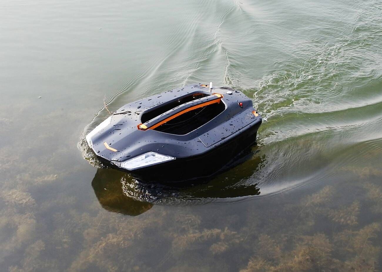 toslon-baitboat A remote-controlled bait boat gliding over calm water, ideal for carp fishing.