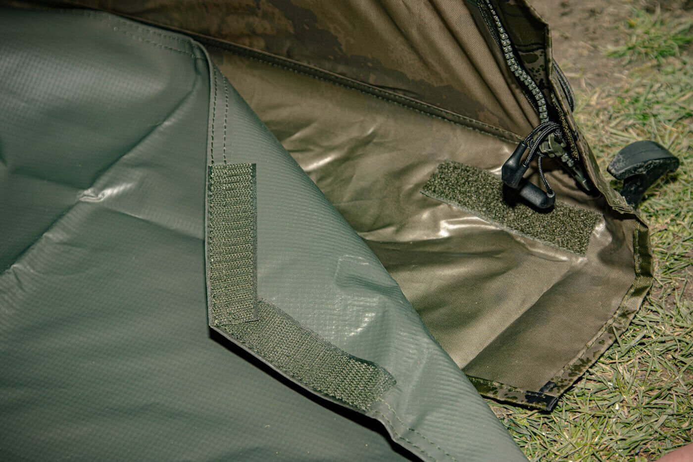 solar-bivvy-CA33-5 Detailní záběr na zip a upevňovací systém odolného rybářského přístřešku pro kapraře.