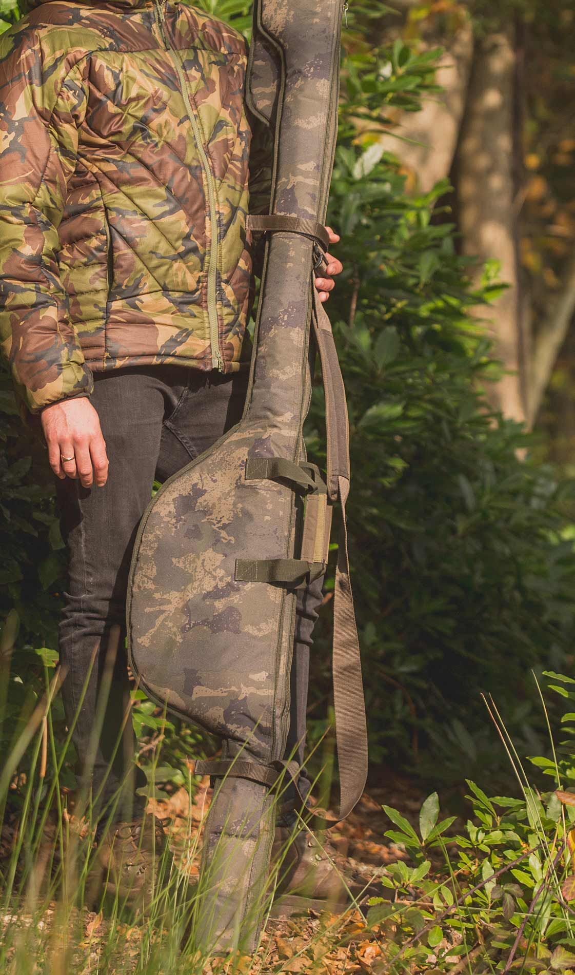 solar-undercover-rod-sleeve-1 Rybář drží pouzdro na camo prut, připravený na den lovu kaprů v přírodě.