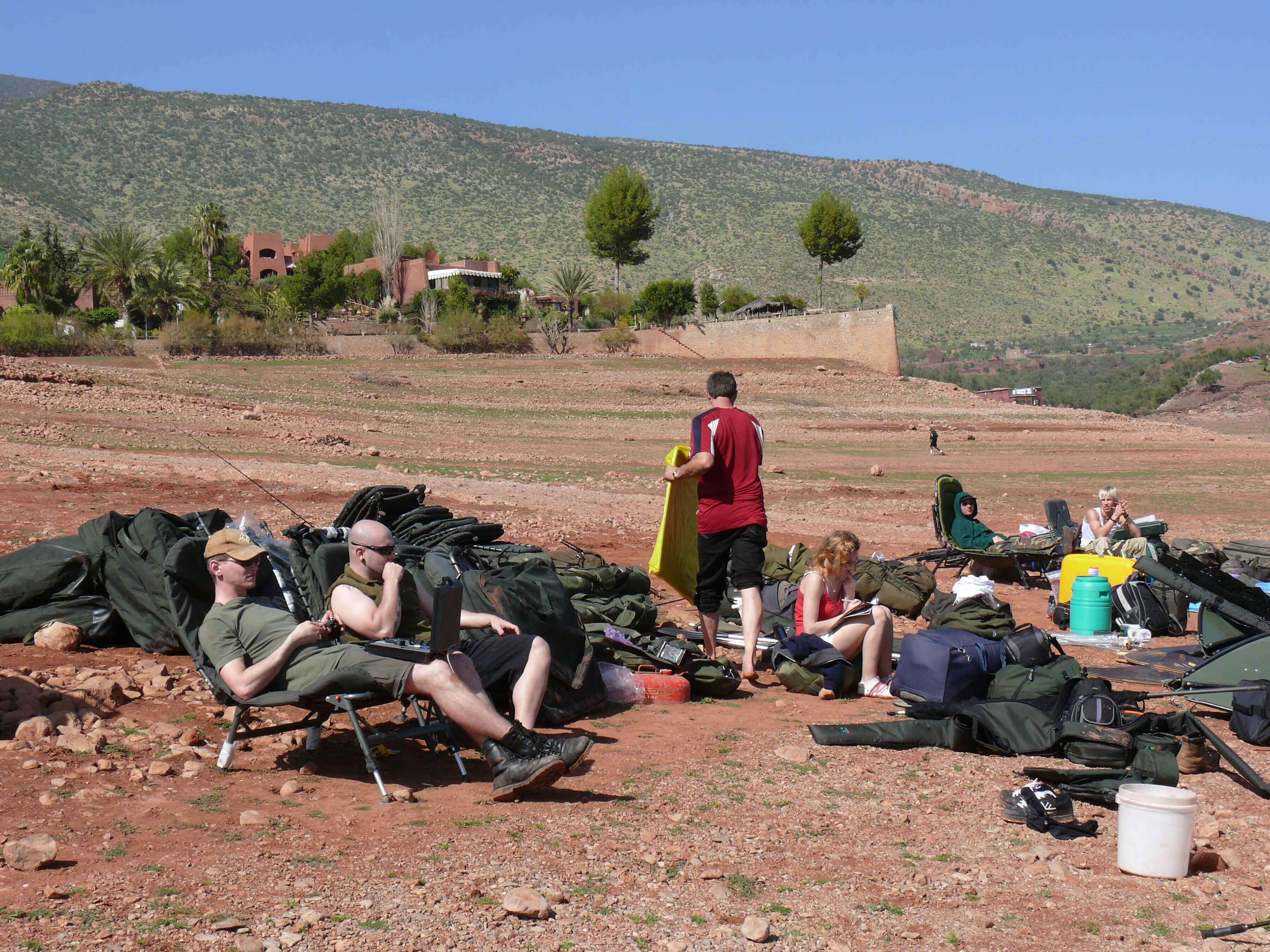 Am-Strand-Bin-El-Ouidane camping, outdoors, camp gear, rocky ground, people relaxing