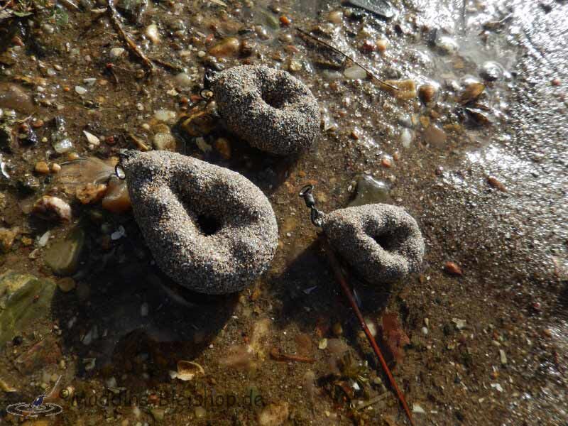 Drie met zand gevulde gewichten voor het karpervissen, ideaal voor het stabiliseren van aas in water.